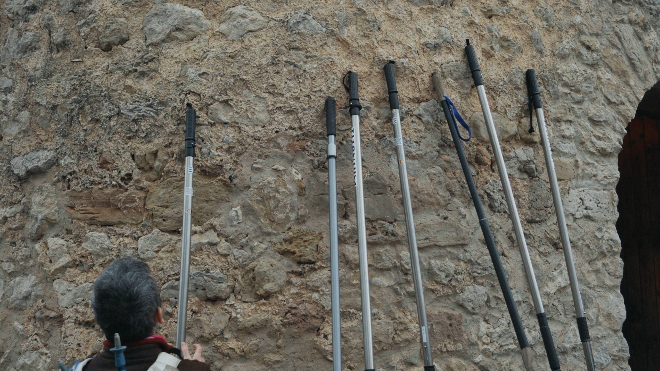 Set barres direccionals recolçades a una paret de pedra