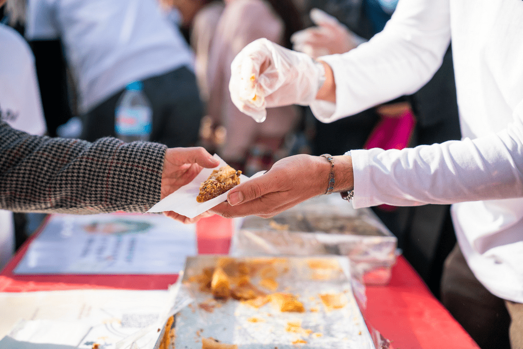 Foto en plano detall de dues mans que s'intercanvien una pasta àrab.