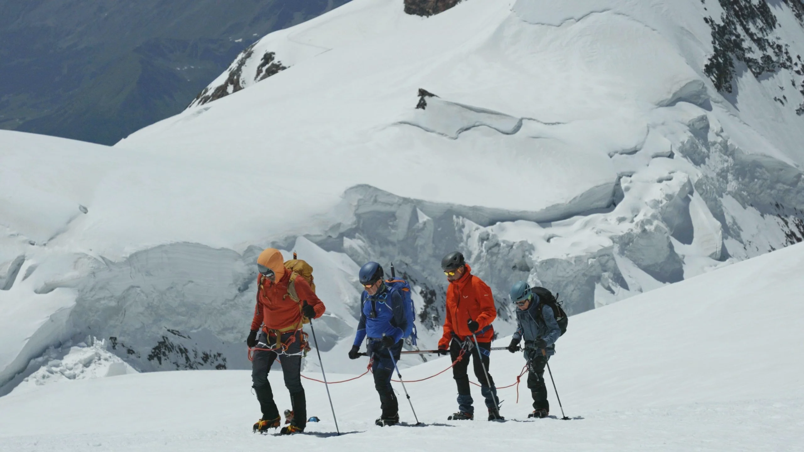 Equip de quatre persones amb la barra direccional i ecnordats fent alpinisme