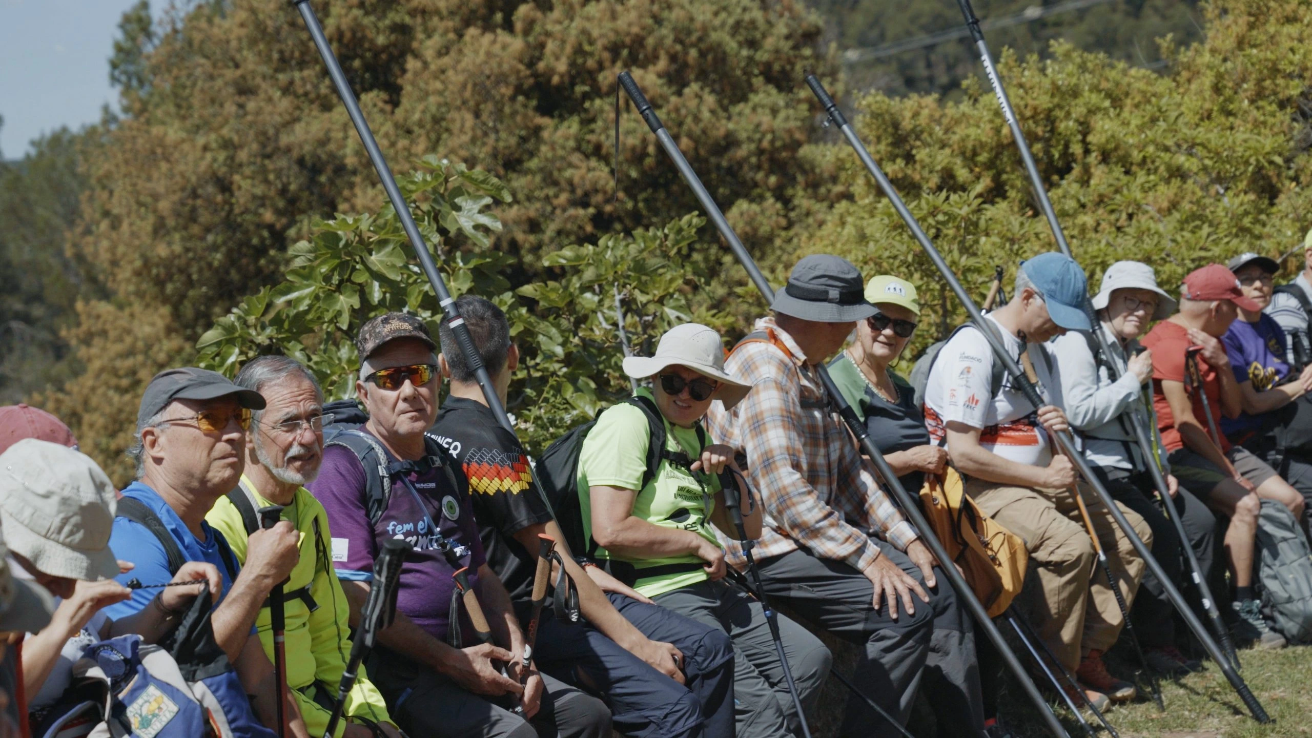 Grup nombrós de persones assegudes amb les barres direccionals en vertical