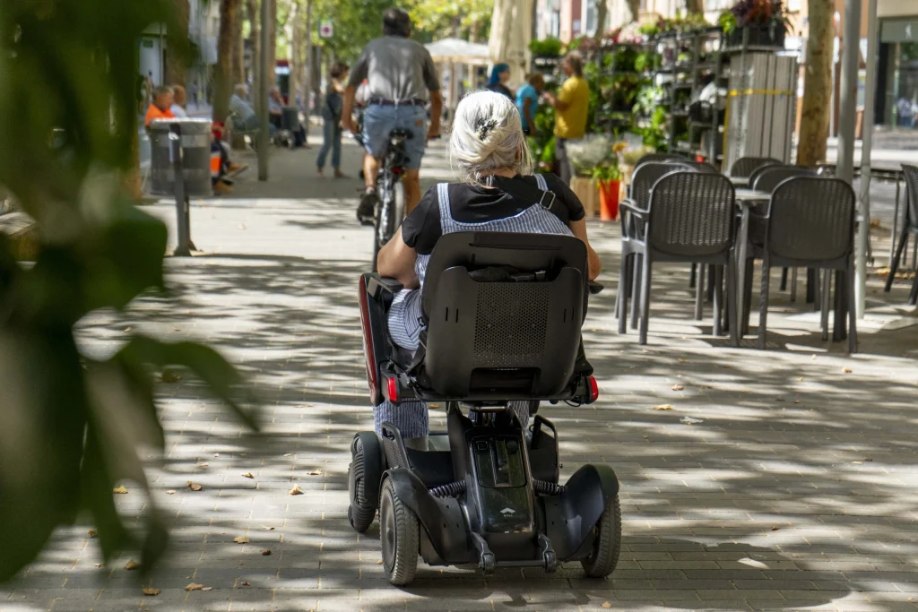 Persona passejant en una cadira de rodes